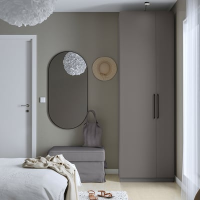 Modernes Schlafzimmer mit hohen, raumhohen FORSAND-Schranktüren und einem runden Spiegel.