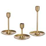 Drei goldene Kerzenständer in unterschiedlichen Höhen mit modernem Design. Messingfarben, schlank und zeitlos, perfekt für die Wohnkultur.