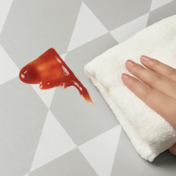 Reinigt den roten Fleck auf der GÅNGPASSAGE-Matte mit einem Handtuch von Hand.