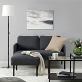 Graues GLOSTAD Sofa, gemütliche, dicke Kissen, schlankes Design. An der Wand, neben dem Couchtisch.