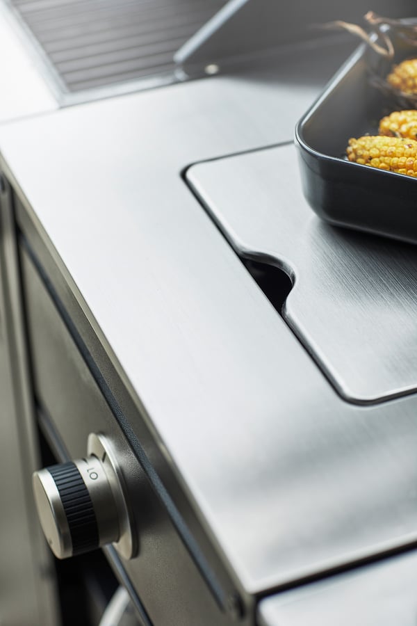 Moderner Gasgrill aus Edelstahl mit schwarzen Bedienknöpfen und Griff.