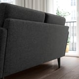 Modernes graues GRILLSTORP-Sofa, schlankes Design, dunkler Holzboden, Blick auf die Stadt. Bequemes, kompaktes Sofa, perfekt für kleine Räume.