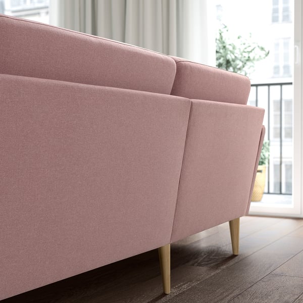 Ein rosafarbenes GRILLSTORP 4-Sitzer-Sofa mit Holzbeinen. Es ist groß und hat ein sauberes, einladendes Design, perfekt für einen gemütlichen Wohnraum.