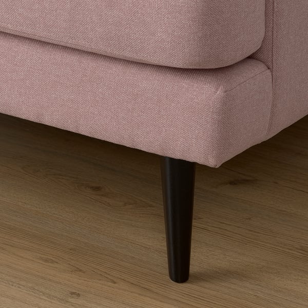 Nahaufnahme eines weichen, einladenden rosa Sofas mit dunklen Holzbeinen, das Komfort und Qualität zeigt.