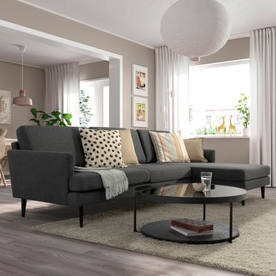 Graues GRILLSTORP 4-Sitzer-Sofa mit Kissen, Teppich, Couchtisch und Fenster.