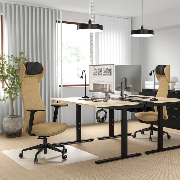 Modernes Homeoffice: zwei beige GRÖNFJÄLL-Stühle mit schwarzen Untergestellen und Kopfstützen an einem Schreibtisch aus hellem Holz mit zwei Monitoren und schwarzen Pendelleuchten über dem Kopf.