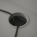 Kreisförmige Kabeldurchführung auf dem Schreibtisch, um elektrische Kabel ordentlich zu verstecken und zu verwalten.
