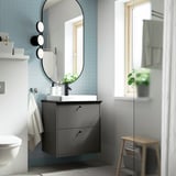Moderner grauer HAVBÄCK-Waschtisch, großer Spiegel, blau geflieste Wand, weißes Waschbecken, kleiner Hocker.