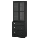 HAVSTA: hoher schwarzer Holzschrank mit Glastüren und drei Schubladen im rustikalen Design.