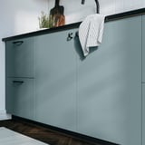Küchenschränke in türkisfarbenem HAVSTORP, schlankes Design, hängendes gestreiftes Handtuch.