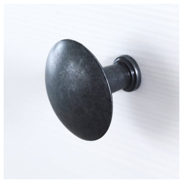 Haken aus schwarzem Metall; robuste, runde Ausführung; an einer schlichten Wand montiert.