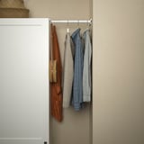 Schrank mit verstellbarer Schiene, an der verschiedene Kleidungsstücke aufgehängt sind.