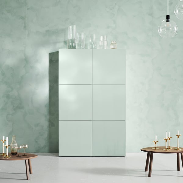 Minimalistisches Zimmer mit weißen HJORTVIKEN-Schränken, Glasvasen und Holztischen mit Kerzen.