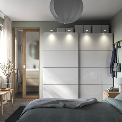 Modernes Schlafzimmer mit HOKKSUND Hochglanzschrank in Hellgrau, Schiebetüren und minimalistischem Design.