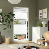 Modernes Büro mit großem Fenster, grüner Pflanze, Schrank und Kunstwerken.
