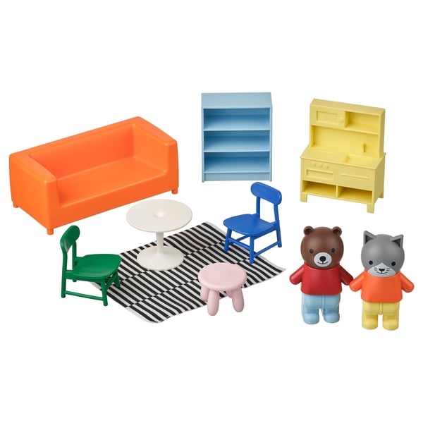 Helles Wohnzimmer-Spielset mit orangefarbener Couch, grünen und blauen Stühlen sowie Bären- und Katzenfiguren auf einem gestreiften Teppich.