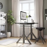 Minimalistisches Büro mit IDÅSEN Schreibtisch, Stuhl und Regalen. Großes Fenster, Uhr und Heizkörper.