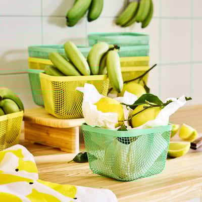 Netzkörbe zur Aufbewahrung von Früchten, mit Zitronen vorne auf der Theke.