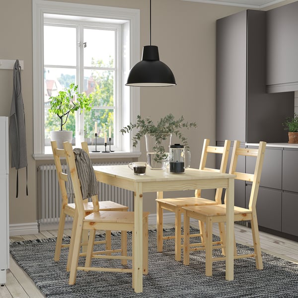 Modernes Esszimmer mit hellem Holztisch und Stühlen, schwarzer Pendelleuchte, grauen Schränken, großem Fenster mit Blick auf den Baum, schwarz-weißem Teppich.