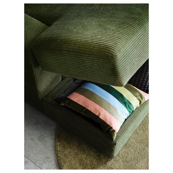 Grünes Cordsofa mit bunt gestreiften Kissen, plüschig und bequem zum Entspannen.