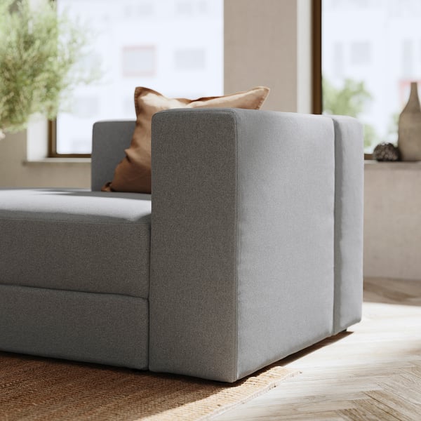 Modernes Sofa in Grau mit braunen Kissen. Weiches, modulares Design mit klaren Linien.