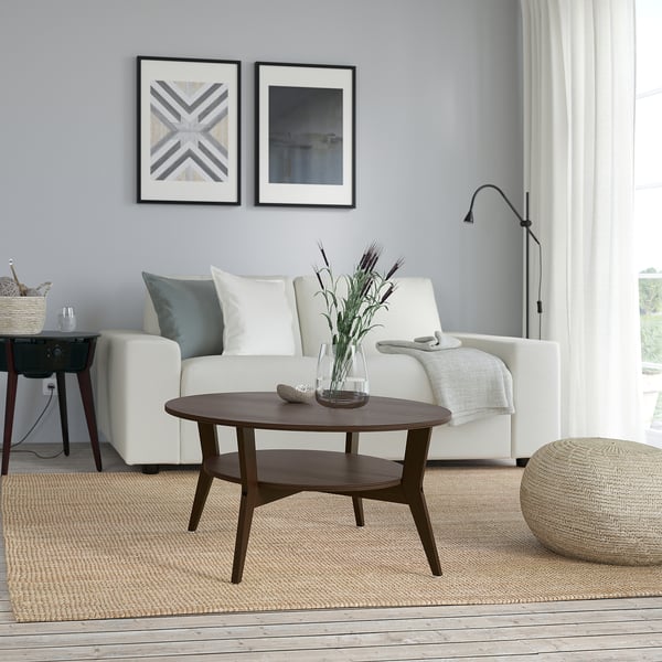 Modernes Wohnzimmer mit JAKOBSFORS Couchtisch, Blumen und Wandkunst.