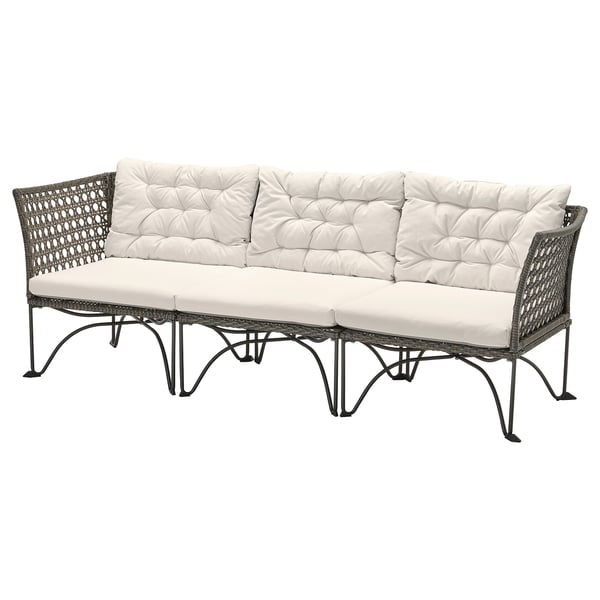 JUTHOLMEN Outdoor-Sofa, beige Kissen, graues Korbgeflecht.
