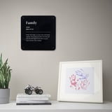 Schwarzes Metall Zeichen Familie über Büchern, Pflanze, Handabdruck Kunst.