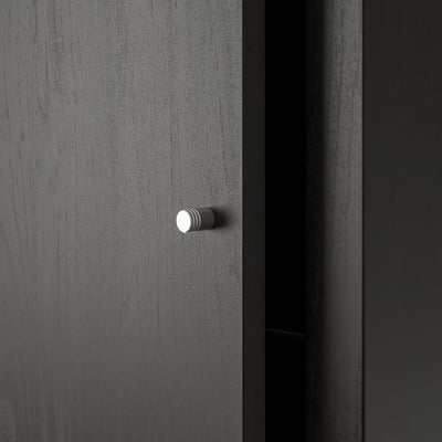 Ein dunkelgraues KALLAX Regal, schlank und modern. Stilvolle Knöpfe für Schubladen, die auf einer glatten, fertigen Oberfläche stehen.