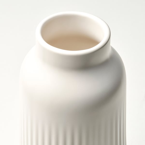 Hohe, matte, cremefarbene Vase mit vertikalen Rillen, glatter Oberfläche, minimalistischem Design.
