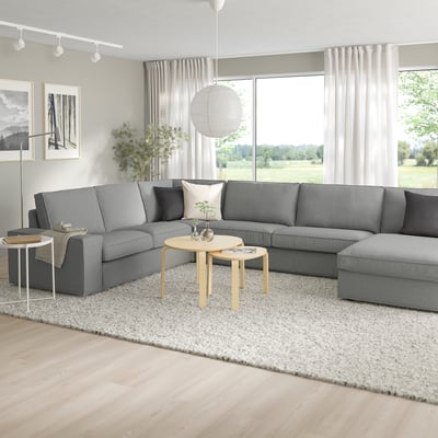 Modernes Wohnzimmer mit KIVIK-Sektion, Couchtisch und großen Fenstern.