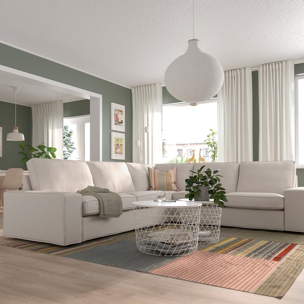 Wohnzimmer mit KIVIK-Sektion, Couchtisch, gestreiftem Teppich, großen Fenstern, grünen Wänden.
