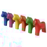 Sechs bunte Dala-Pferde aus Keramik in einer Reihe, lebendige Farben, glatte Oberflächen, schlichtes Design.