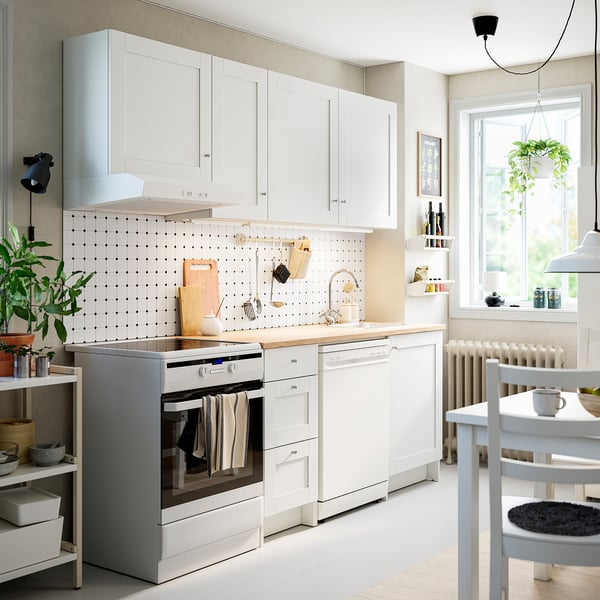Moderne weiße KNOXHULT-Küche mit Schränken, Theke, Backofen, Geschirrspüler, minimalistischem Design.