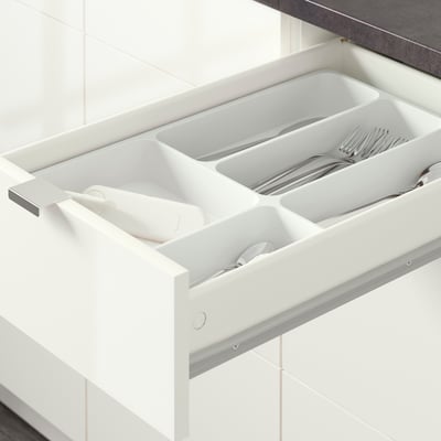 Offene Küchenschublade mit Besteck-Organizer: Löffel, Gabeln, Messer in separaten Fächern.