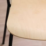 Moderner Konferenzstuhl aus Birkenfurnier, glatte, abgerundete Kanten, schwarze Metallbeine, sauberes, robustes Design.