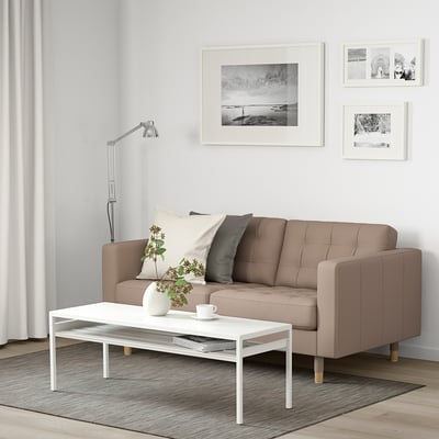 Modernes Wohnzimmer mit LANDSKRONA-Sofa, weißem Couchtisch und schwarz/weißer Wandkunst.