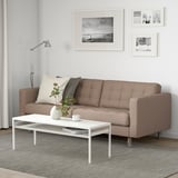 Ein minimalistisches Wohnzimmer mit einem braunen LANDSKRONA-Sofa, einem weißen Couchtisch, Schwarz-Weiß-Kunst und einer Blumenvase.