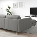 Modernes Wohnzimmer mit grauem LANDSKRONA-Sofa, elegantem TV-Ständer und Wandkunst. Das Sofa ist groß, mit Kissen und Holzbeinen.