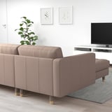 Modernes Wohnzimmer mit grauem LANDSKRONA-Sofa, Kissen, weißem TV-Ständer, Pflanze und Wandkunst.