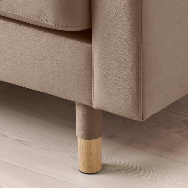 Nahaufnahme eines modernen Sofabeins, das feine Handwerkskunst mit Holzgestell und polierter Oberfläche zeigt.