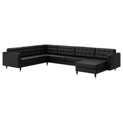 Schwarzes L-förmiges Ledersofa mit gepolstertem Sitz und Rückenlehne, Holzbeinen.