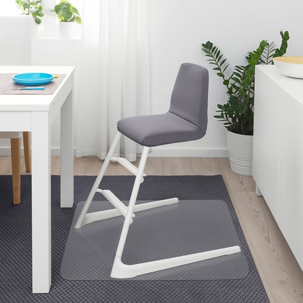 Moderner Kinderstuhl, grau, weiße Beine, gepolsterter Sitz. Ideal für kleine Räume neben weißem Schreibtisch und Topfpflanze.
