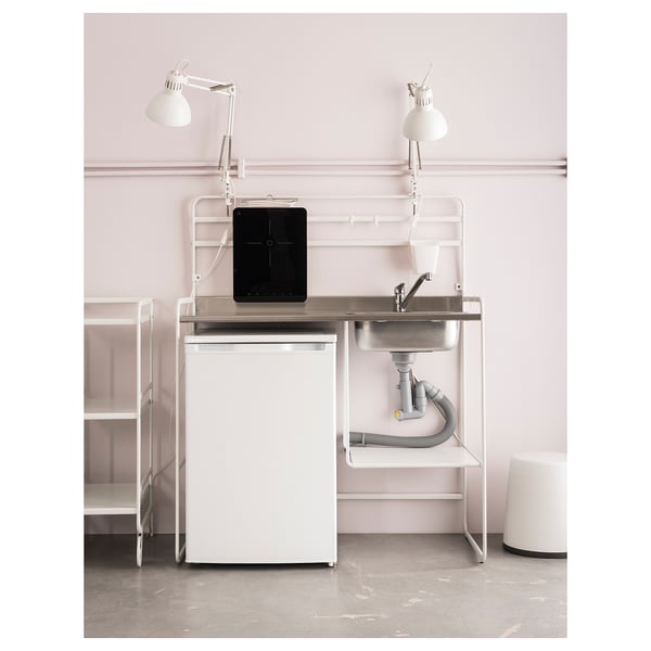 Minimalistische Kücheneinrichtung mit weißer LILLVIKEN-Spüle, kleinem Kühlschrank und Lampen. Spüle aus Edelstahl, Kunststoffteile, klares Design.