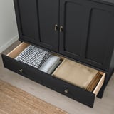 Schwarzer Schrank mit offener Schublade mit gefalteten Handtüchern und Einlagen mit Soft-Close-Funktion.