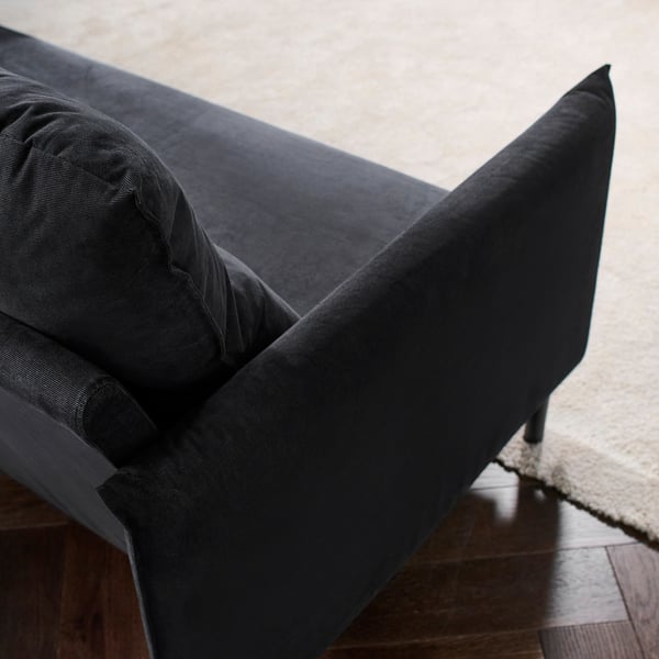 Dunkelgraues Sofa mit elegantem Design, stützenden Polstern und auffälligen Nähdetails.