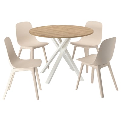 Eine MARIEDAMM Essgarnitur mit einem hellbraunen runden Tisch und vier beigen Stühlen in einem modernen, minimalistischen Design mit Holz- und Kunststoffmaterialien.