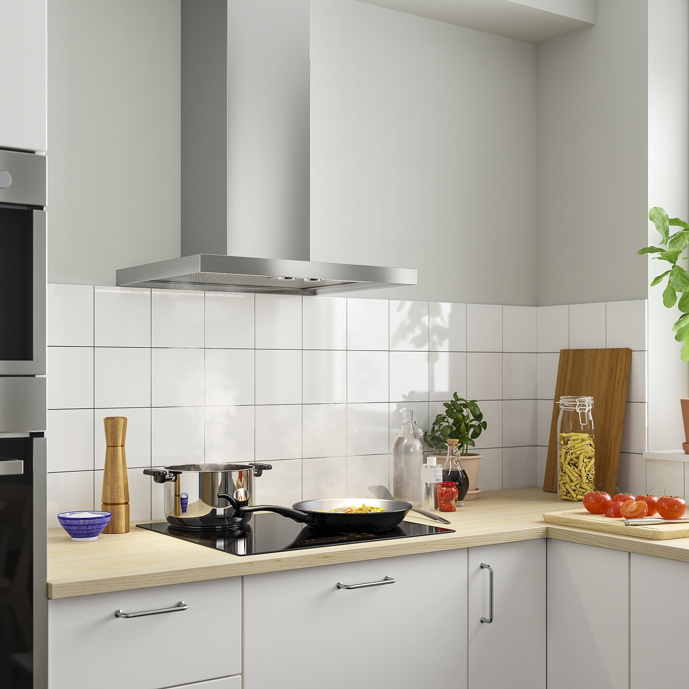 Moderne Küche mit MATÄLSKARE Dunstabzugshaube. Edelstahl, schlankes Design. Weiße Schränke, Holztheke. Pfanne auf dem Herd kochen.