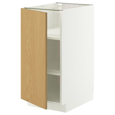 Ein weißer METOD-Küchenschrank mit einer hellen Eichentür mit minimalistischem Design und verstellbaren Regalen.