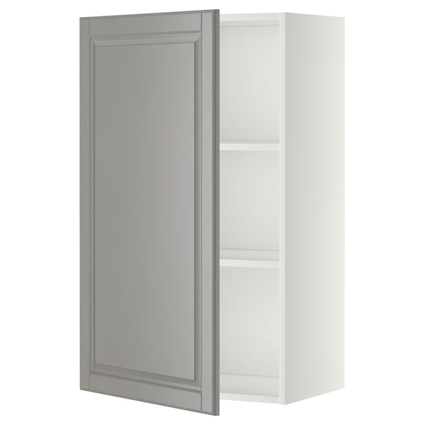 Ein weißer METOD-Küchenschrank mit einer grauen Tür mit abgeschrägten Kanten. Das Design ist traditionell, mit einem Holzrahmen und verstellbaren Regalen.